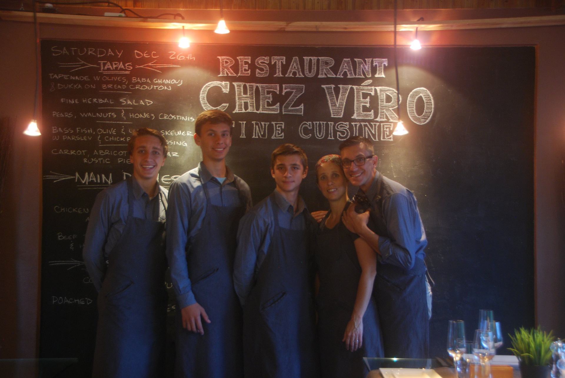 Jean-François, Véro, Georges-Étienne, Laurent et Julien devant le tableau noir du restaurant Chez Véro Fine Cuisine, à Jarabacoa